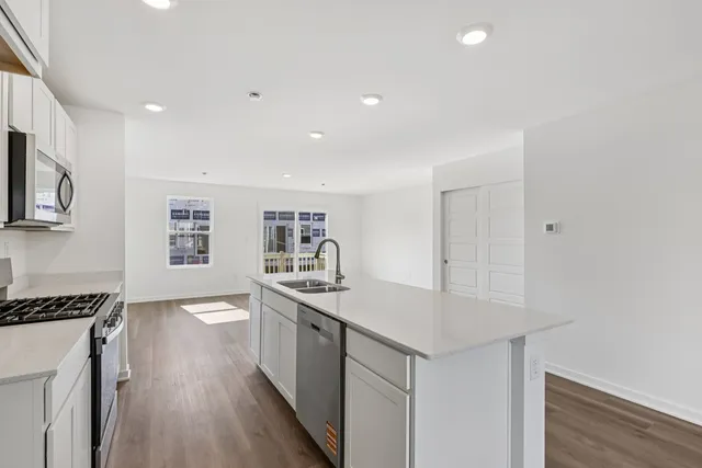 a kitchen with granite countertop a sink and a stove top oven