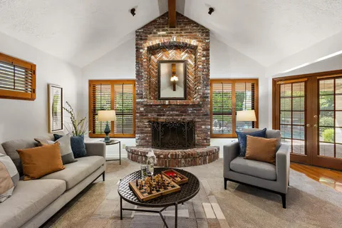 a living room with furniture a fireplace and a large window