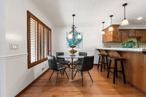 a dining room with furniture window and wooden floor