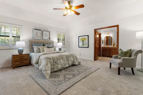 a bedroom with a large bed couch and a window