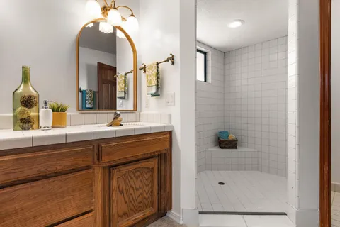 a bathroom with a sink a mirror a vanity and bathtub