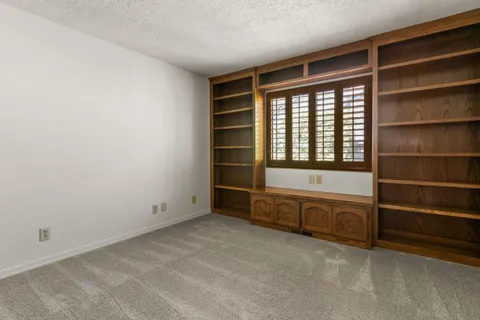 a view of an empty room with a fireplace and cabinets