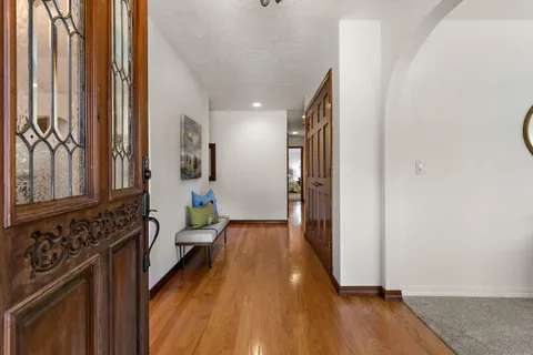 a view of a hallway with wooden floor and staircase