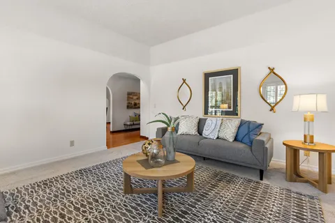 a living room with furniture a mirror and a table