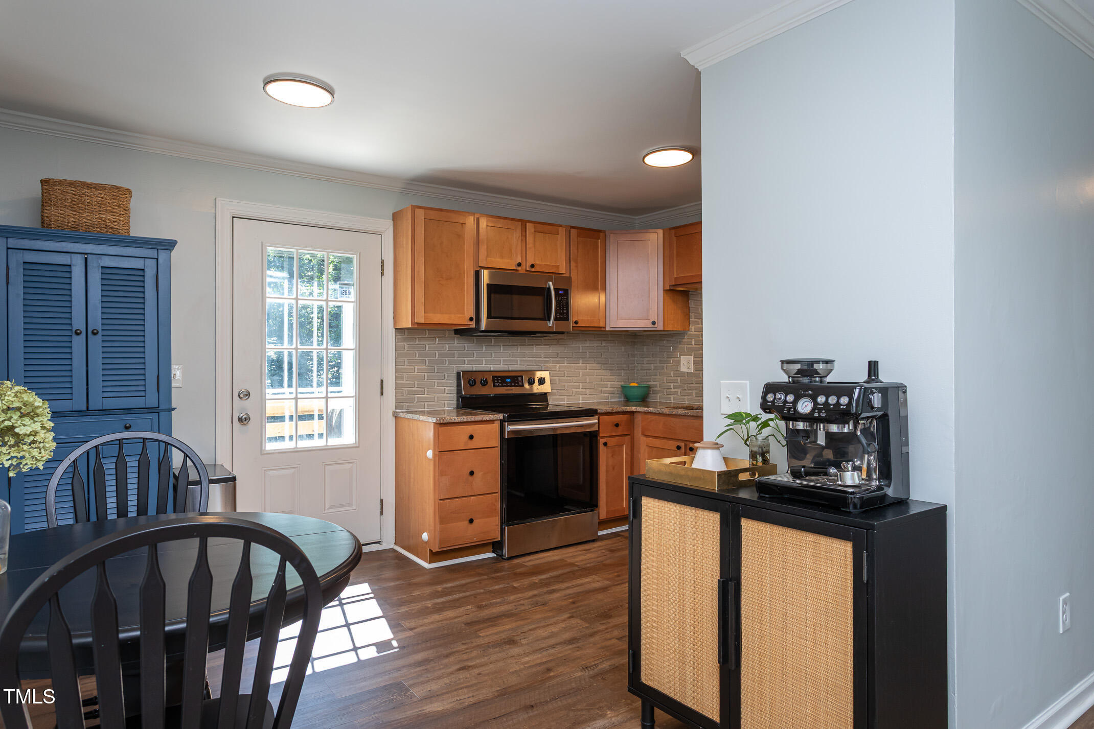 7412 Mine Shaft Road Raleigh, NC 27615 - Photo 4 of 16 a kitchen with granite countertop a stove top oven a sink a dining table and chairs