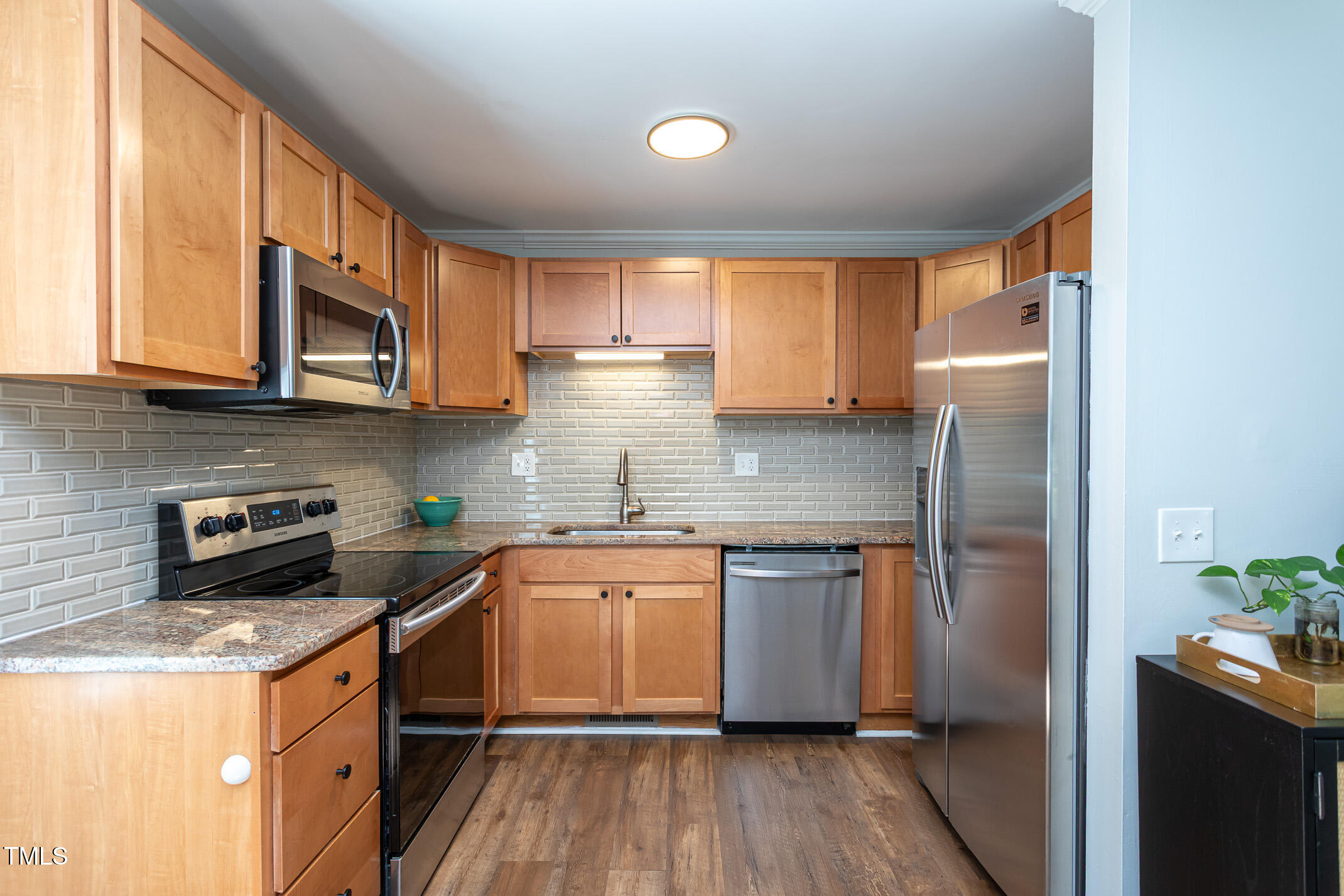 7412 Mine Shaft Road Raleigh, NC 27615 - Photo 5 of 16 a kitchen with stainless steel appliances granite countertop wooden cabinets granite counter tops and a hard wood floors