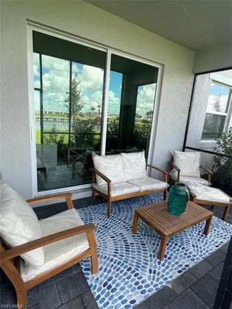 a living room with patio furniture and a rug