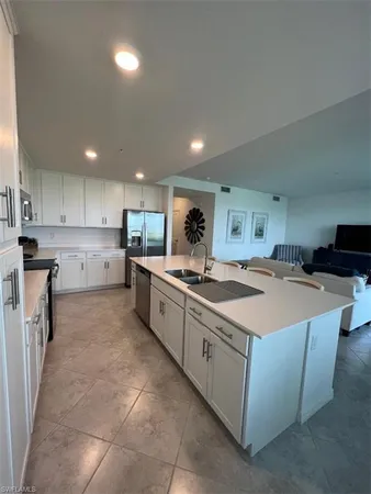 a large kitchen with stainless steel appliances a sink a stove and a refrigerator