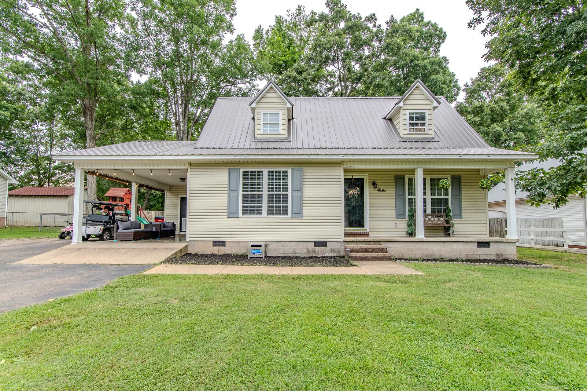 a front view of a house with a garden and trees