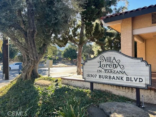 a view of a street sign under a large tree
