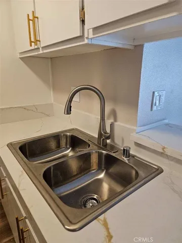 a close view of a sink a counter and appliances in a kitchen