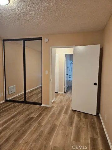 an empty room with wooden floor and entrance