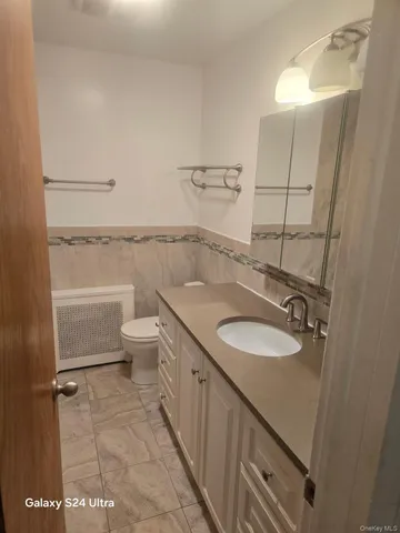 a bathroom with a toilet a sink and mirror