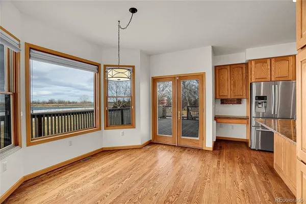 a view of a kitchen with wooden floor and outdoor space