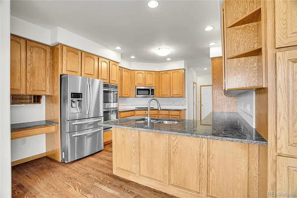 a kitchen with granite countertop a refrigerator and a sink