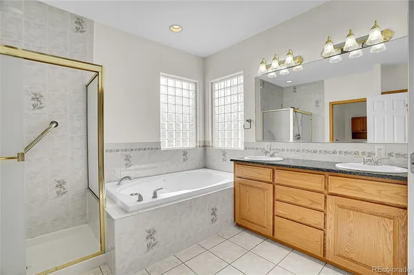 a bathroom with a granite countertop bathtub a sink and a large mirror