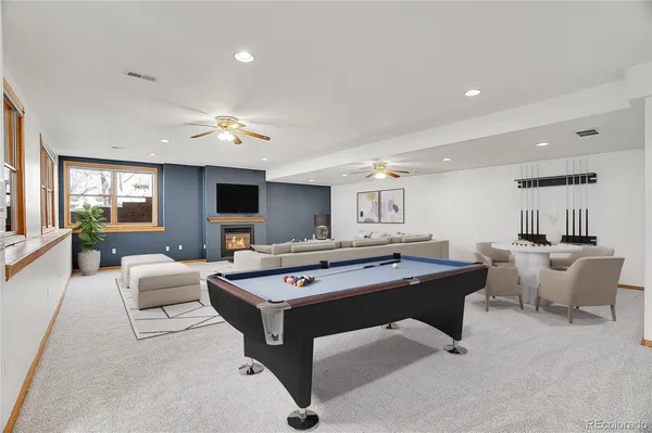 a living room with furniture a flat screen tv and a pool table