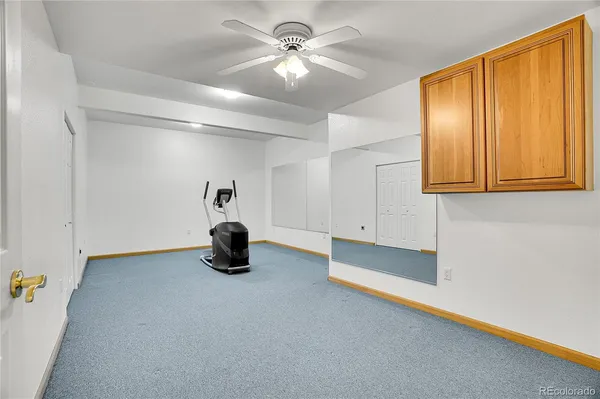 a view of an empty room with window and a ceiling fan
