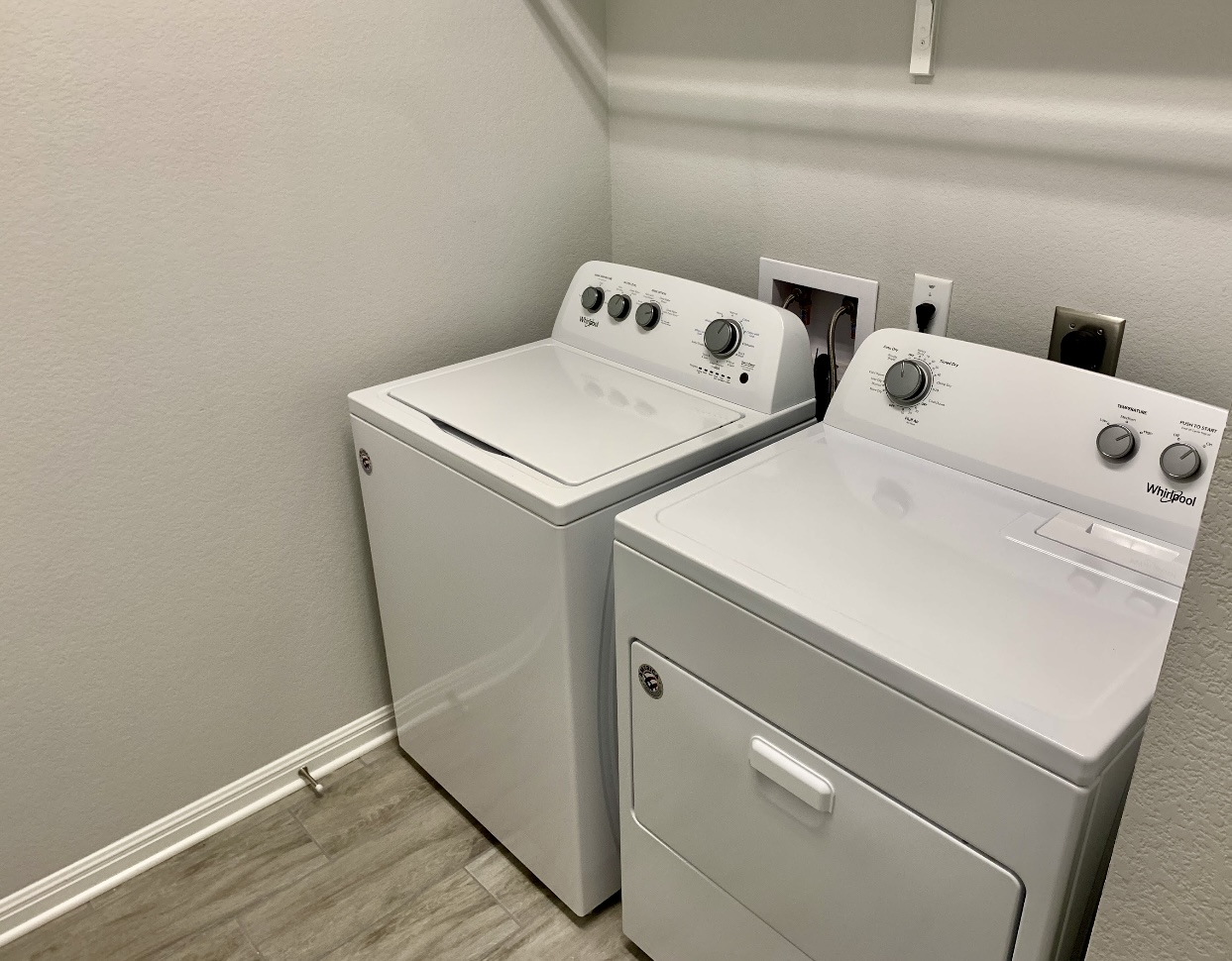 119 Wild Wind Cove Jarrell, TX 76537 - Photo 10 of 16 Washroom featuring washing machine and clothes dryer, light wood-style floors, and baseboards