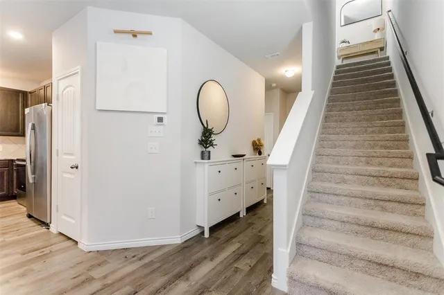 a view of a hallway with wooden floor and entryway