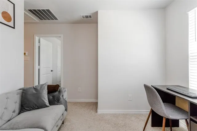 a view of a workspace with furniture and a window