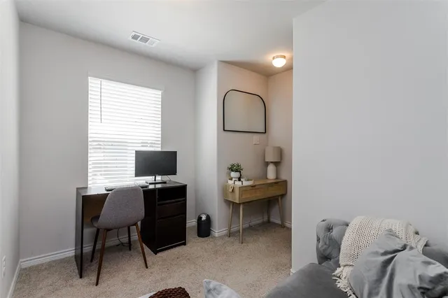 a bed sitting in a bedroom next to a window and a chair