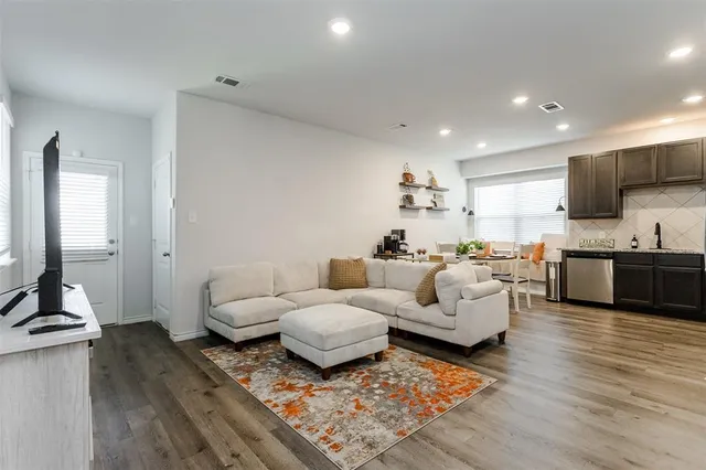 a living room with furniture and a wooden floor