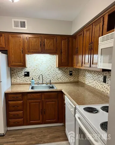 a kitchen with granite countertop a sink stove and cabinets