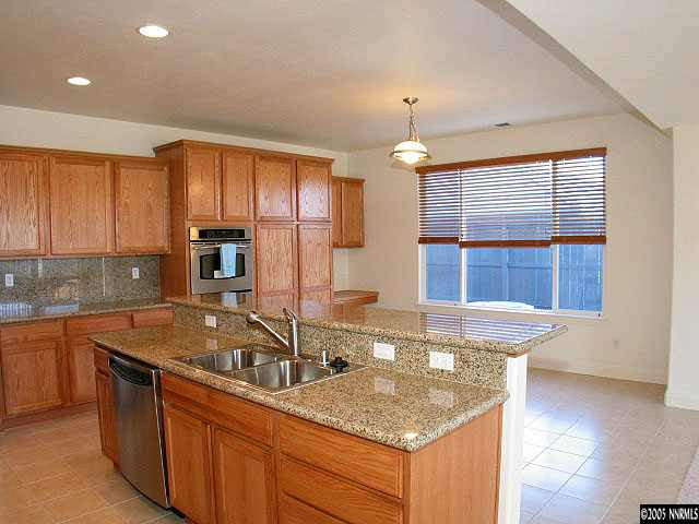 661 Caspian Court Reno, NV 89521 - Photo 5 of 9 a kitchen with granite countertop a sink a counter top space cabinets and stainless steel appliances