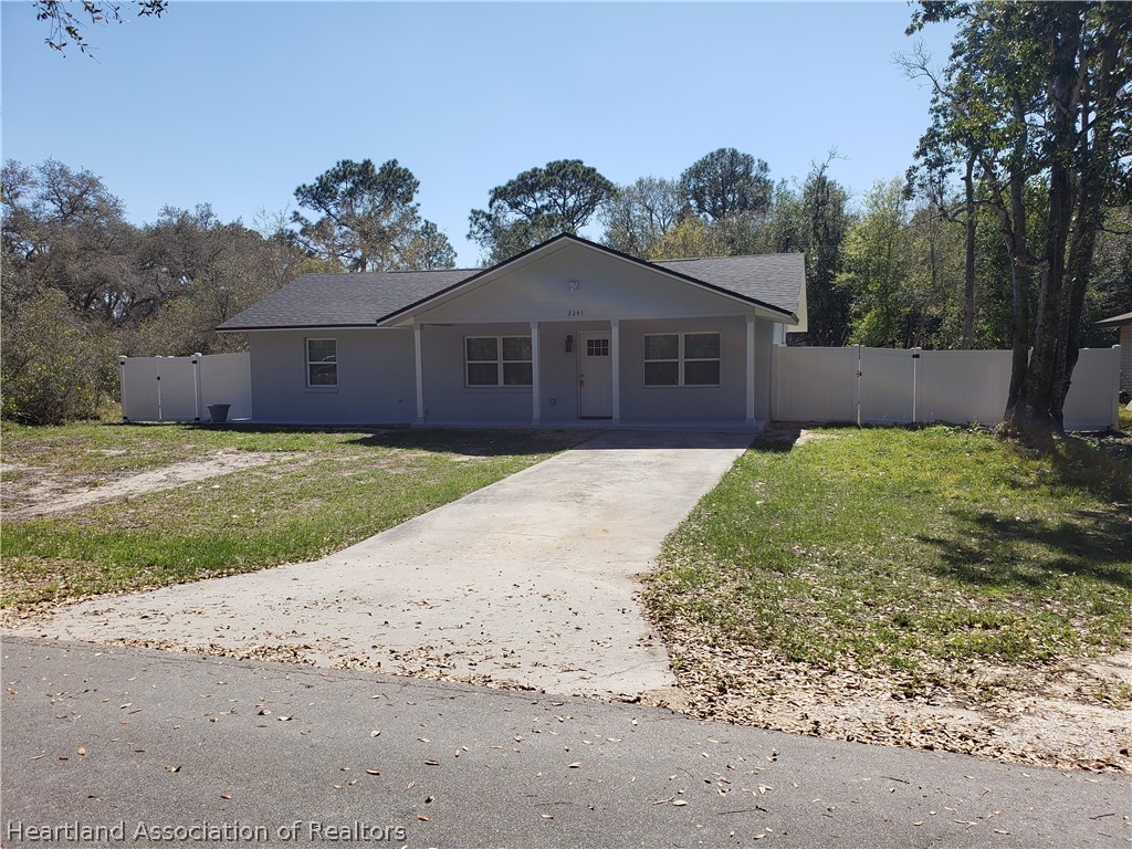 a view of a yard in front of a house with large windows