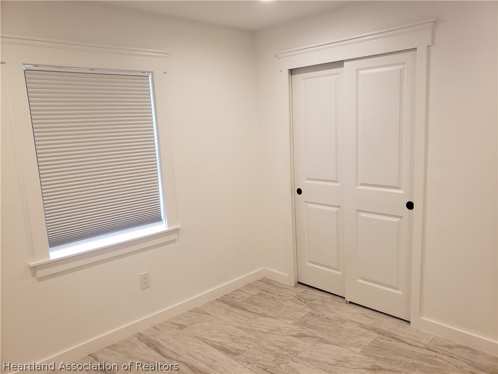 2247 West Longbottom Road Avon Park, FL 33825 - Photo 12 of 21 a view of an empty room with wooden floor and a window