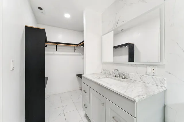 a bathroom with a granite countertop sink a mirror and a shower