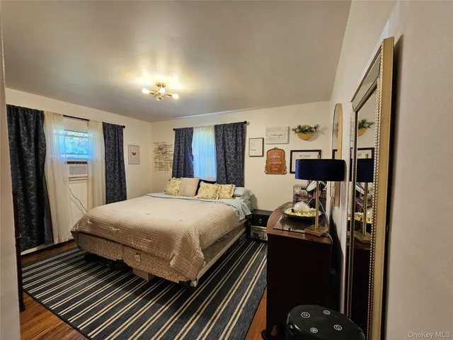 a bedroom with bed and a flat tv screen on dresser