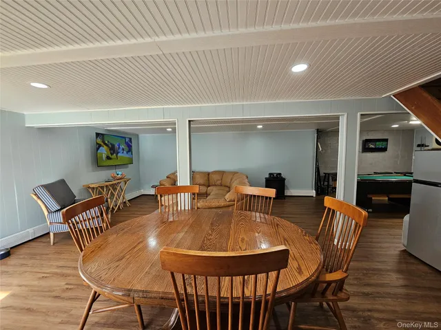 a room with wooden floor pool table and windows