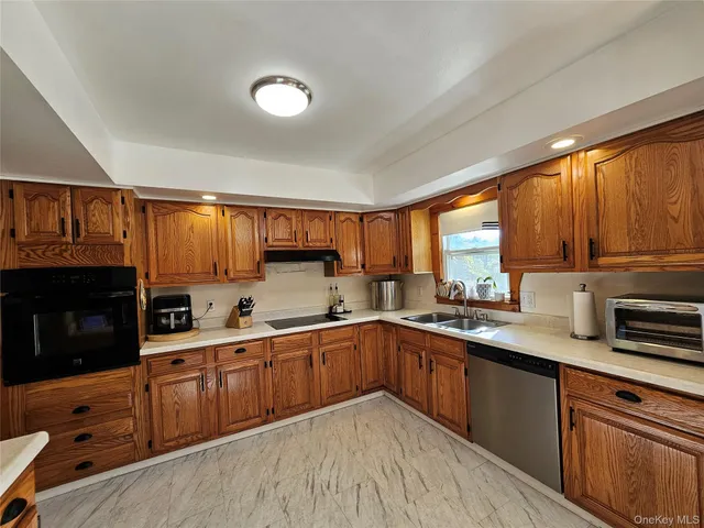 a kitchen with stainless steel appliances granite countertop a sink window and cabinets