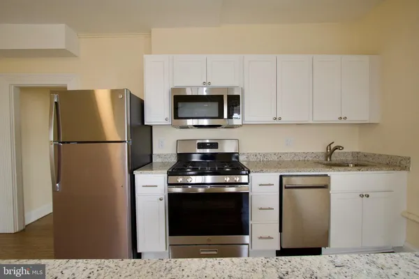 a kitchen with stainless steel appliances granite countertop a stove a refrigerator and a granite counter tops