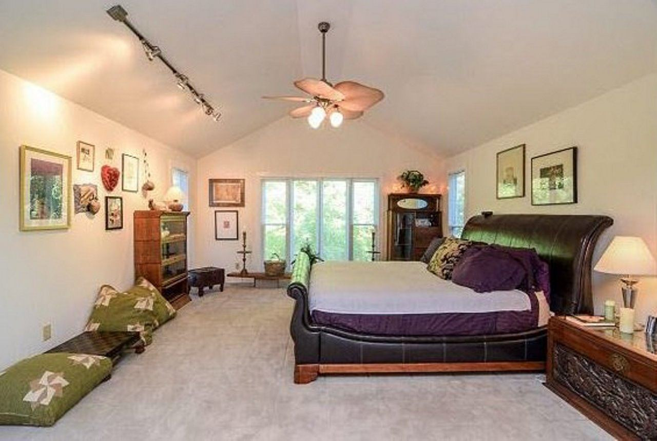 6909 Slade Hill Road Raleigh, NC 27615 - Photo 11 of 25 Huge master suite w/great light (windows on 3 sides), cathedral ceiling w/fan, sitting room, glamour bath, 4 closets. The "one of a kind" floor looks like limestone but is actually VERY thick carpet that has been hand sculpted in place to look like stone. Master Bedroom