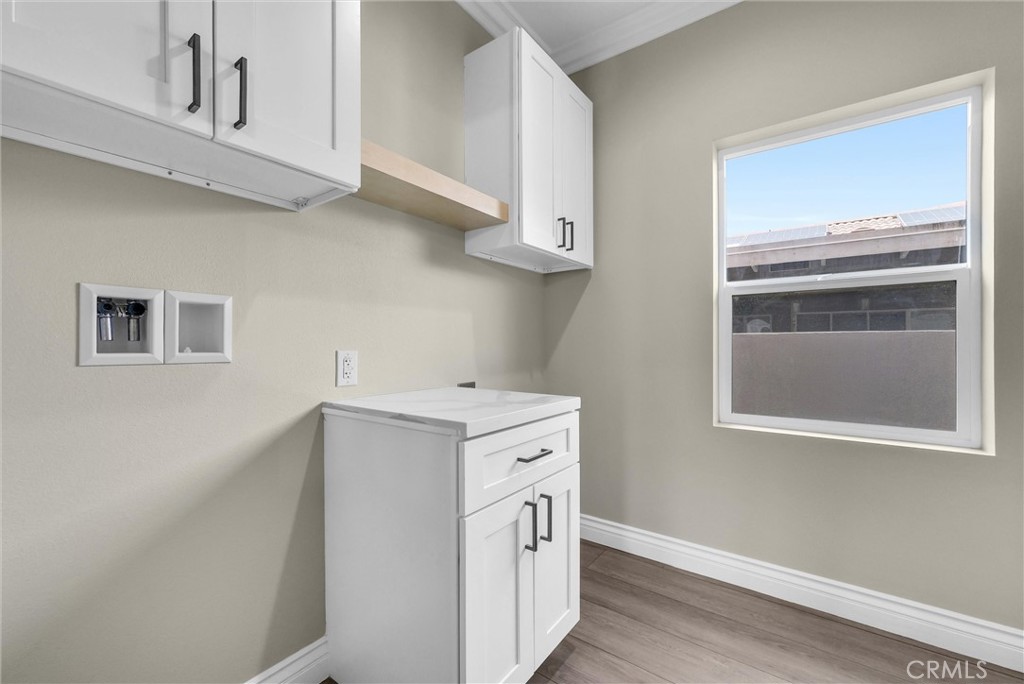 14388 Dove Canyon Drive Riverside, CA 92503 - Photo 12 of 38 a view of a kitchen with white cabinets and wooden floor