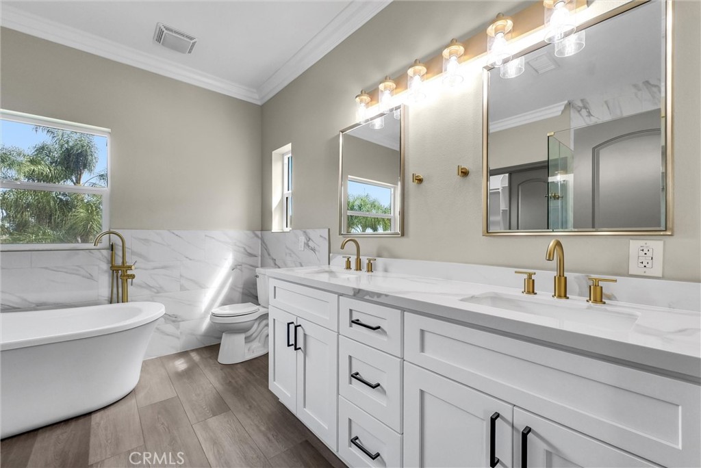 14388 Dove Canyon Drive Riverside, CA 92503 - Photo 28 of 38 a spacious bathroom with a double vanity sink a mirror and a toilet