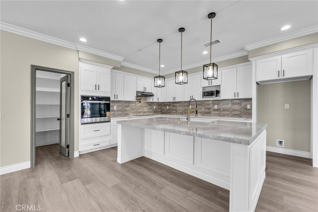 14388 Dove Canyon Drive Riverside, CA 92503 - Photo 6 of 38 a kitchen with stainless steel appliances granite countertop a sink a stove a refrigerator and island with wooden floor