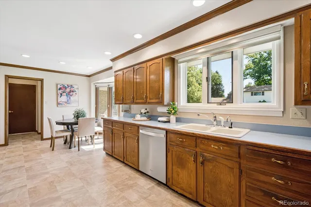 a large living room with stainless steel appliances kitchen island granite countertop a table and chairs in it