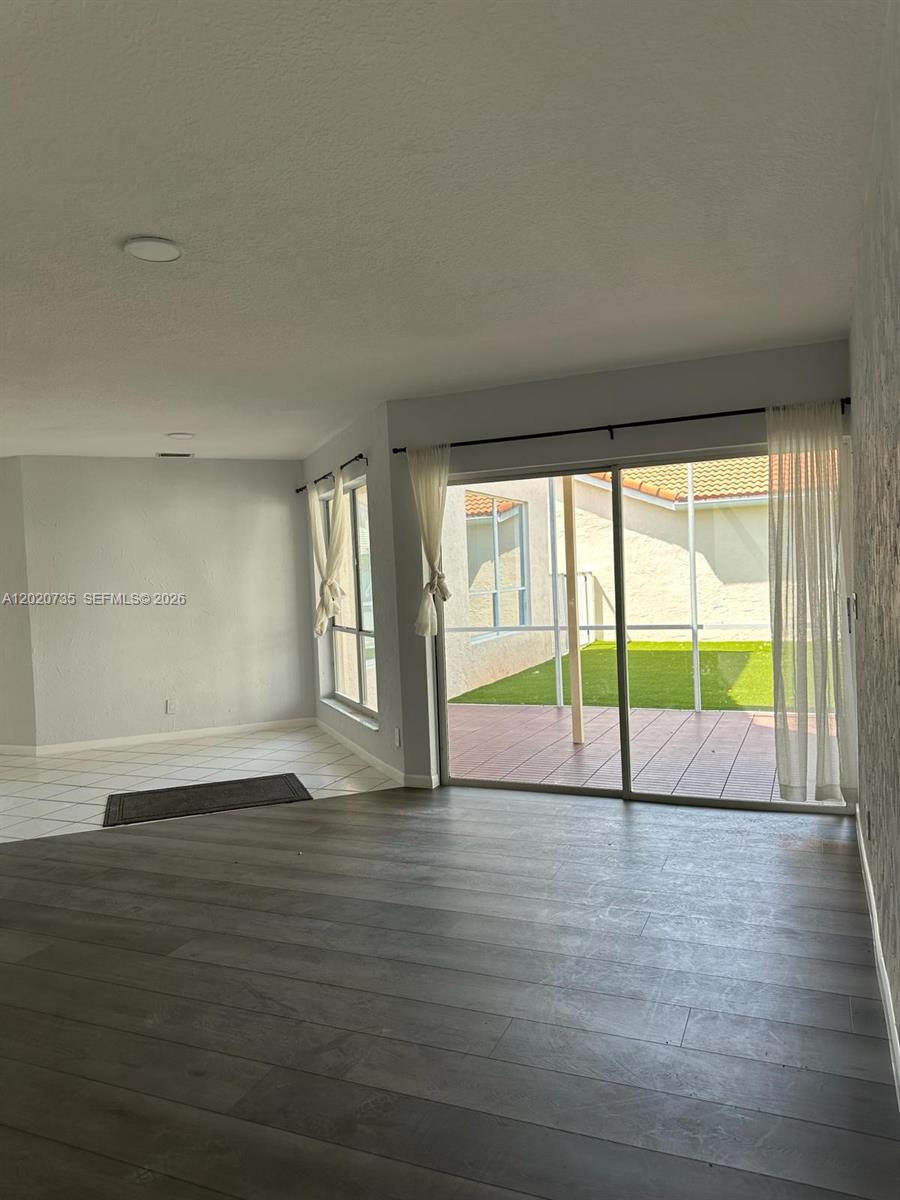 17244 Balboa Point Way Boca Raton, FL 33487 - Photo 10 of 66 a view of an empty room with wooden floor and a window