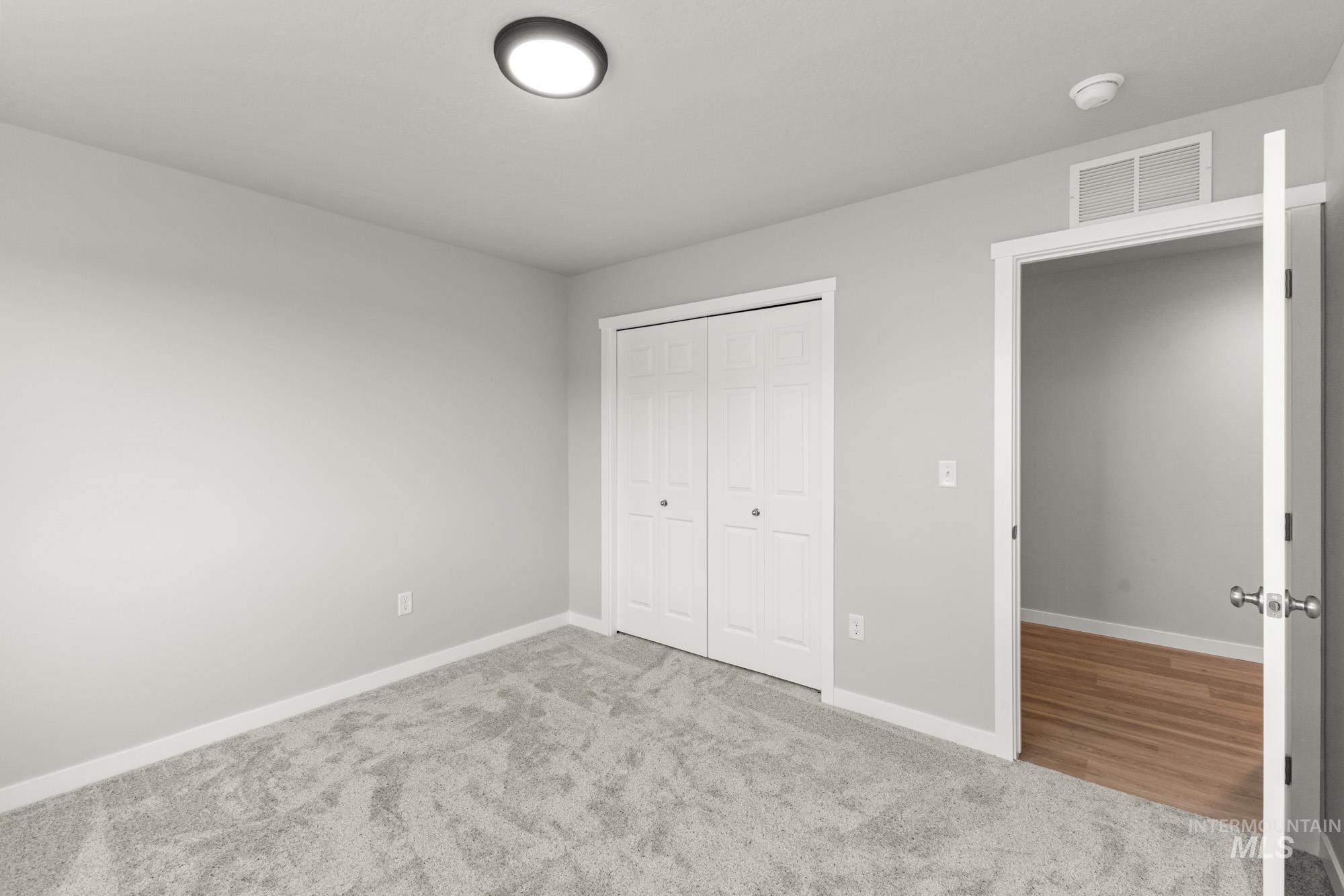 436 Merlin Court Middleton, ID 83644 - Photo 10 of 20 Carpeted room featuring light gray walls, white baseboards, and a flush mount ceiling light