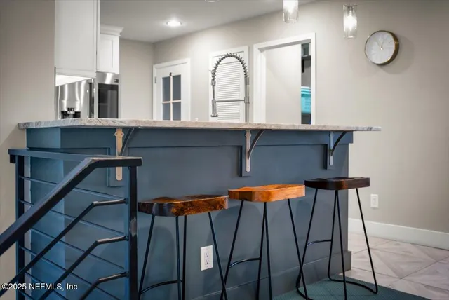 a kitchen with granite countertop white cabinets and stainless steel appliances
