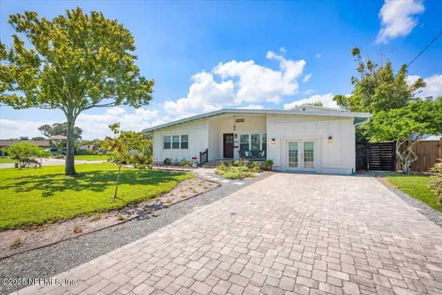 a view of a house with backyard and sitting area