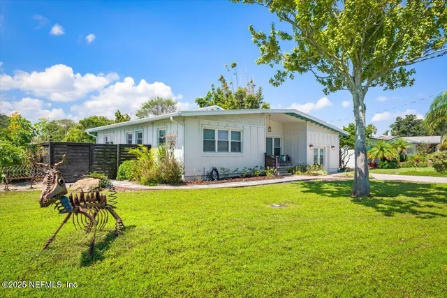 a white house with garden in front of it