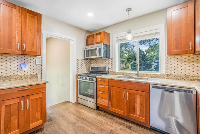 a kitchen with stainless steel appliances granite countertop a stove a sink dishwasher and a refrigerator
