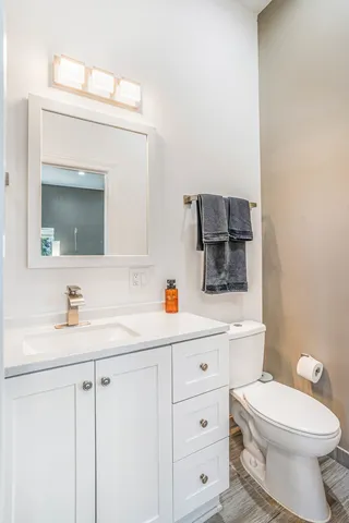 a bathroom with a toilet sink double vanity and mirror