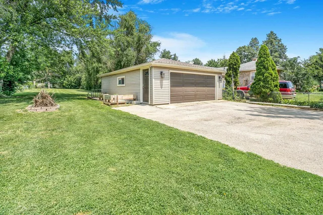 a front view of house with yard and trees in the background
