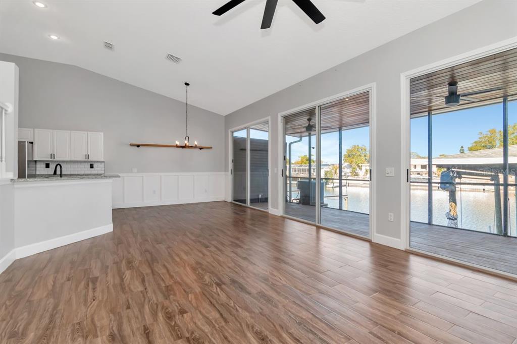 5313 Boardwalk Street Holiday, FL 34690 - Photo 26 of 69 a view of empty room with wooden floor and kitchen view